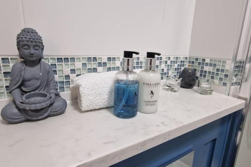 a bathroom counter with two bottles of soap and aitatingitatingitatingitatingitatingitating at Pear Apartment York City Centre - Self Check-in in York