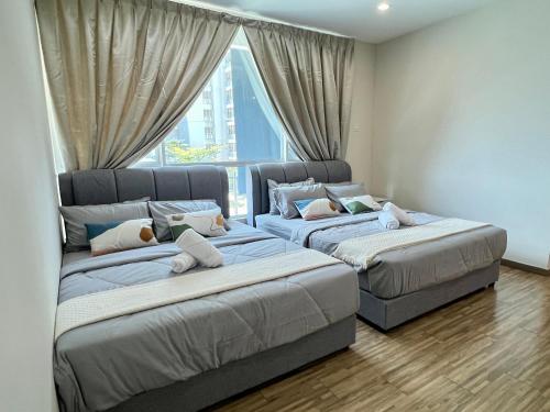 two beds in a room with a window at Setapak Cozy 4-6 Pax Suite ZetaPark by CITYSPACE in Kuala Lumpur