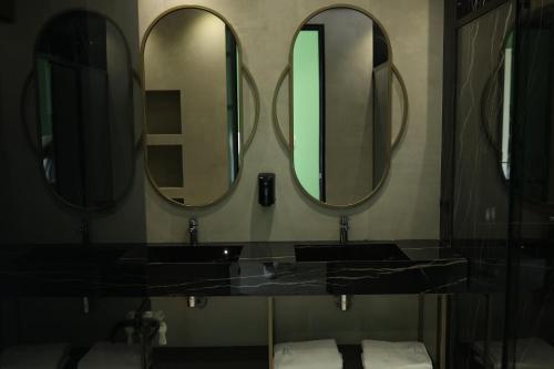 a bathroom with two sinks and three mirrors at Comfort Suites in Golem