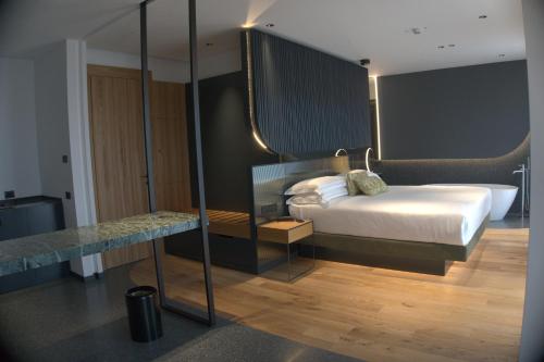 a hotel room with a bed and a bath tub at Hotel Ristorante Al Caminetto WorldHotels Crafted Adults Only in Torri del Benaco