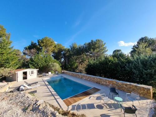 une piscine avec des chaises et un mur en pierre dans l'établissement Villa 