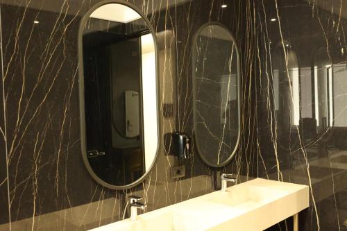 a bathroom with two sinks and two mirrors at Comfort Suites in Golem