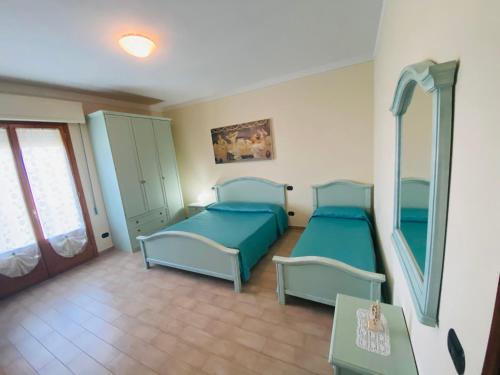 1 dormitorio con 2 camas y espejo en Country House Tenuta Fornacelle, en San Gimignano