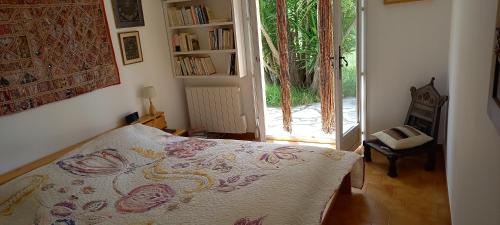 una camera da letto con un letto e una porta scorrevole in vetro di Villa conviviale au soleil avec piscine a Seillans