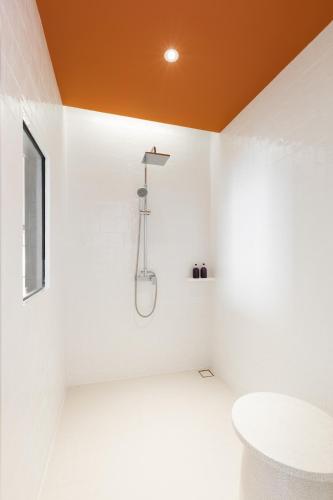 a bathroom with white walls and an orange ceiling at Centara Ayutthaya in Phra Nakhon Si Ayutthaya