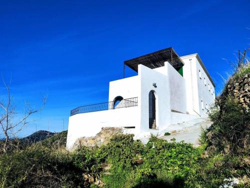un edificio bianco sul fianco di una collina di A Casa Praoli - Coin de paradis vue mer ad Aregno