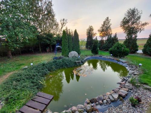 a pond in the middle of a yard with a bench at Ferienhaus Jamshidi in Waren