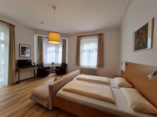 a bedroom with a bed and a living room at Hotel Garni Steiermark in Bad Reichenhall