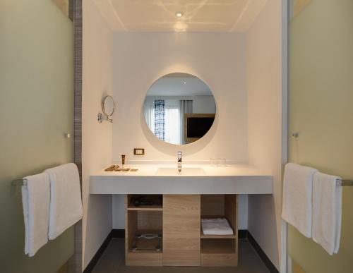 a bathroom with a sink and a mirror at Novotel Chiangmai Nimman Journeyhub in Chiang Mai