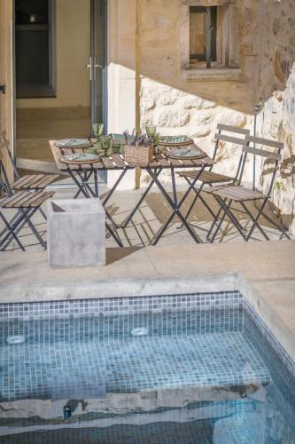 - une piscine avec une table, des chaises et une table dans l'établissement L'annexe des Alpilles, à Maussane-les-Alpilles