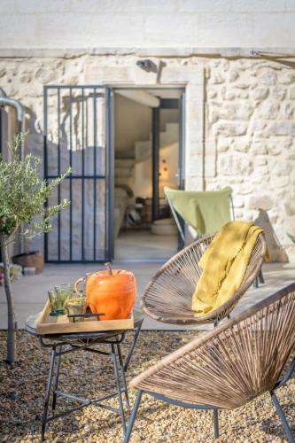 - une terrasse avec 2 chaises et une table avec un oreiller dans l'établissement L'annexe des Alpilles, à Maussane-les-Alpilles