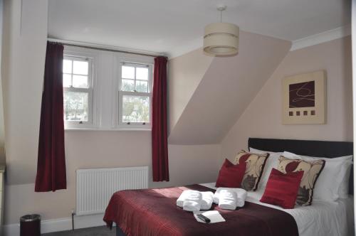 a bedroom with a bed with red and white pillows at Hotel Peppers in Torquay