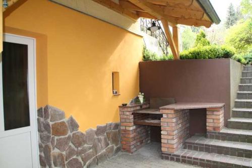a cat sitting on a stone fireplace next to a house at Pension Villa Martha in Burg Stargard