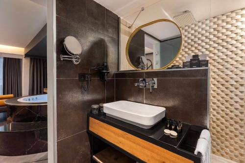 a bathroom with a sink and a mirror at Afflon Hotels Loft City in Antalya