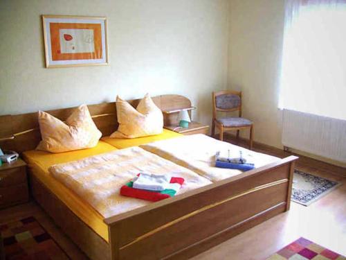 1 dormitorio con 1 cama con almohadas y silla en Ferienhaus Schöne, 