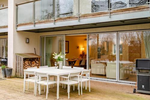 a white dining table and chairs on a patio at Songthrush in Somerford Keynes