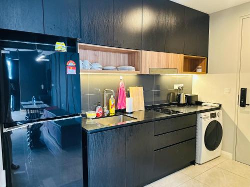 a kitchen with a sink and a washing machine at KL SUITES AT AXON RESIDENCE KLCC in Kuala Lumpur