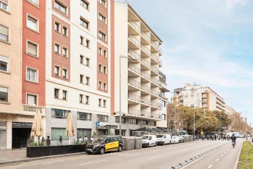 バルセロナにあるホテル ベスト オート ホガールの路上に黄色い車が停まった建物のある通り