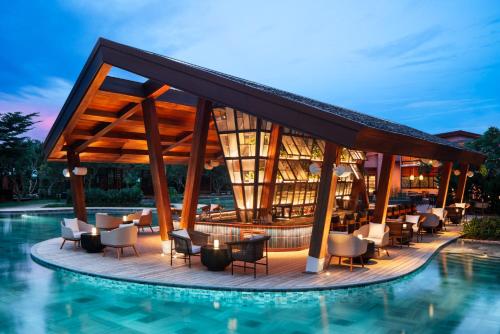 un complejo con piscina, mesas y sillas en New World Hoiana Beach Resort en Hoi An