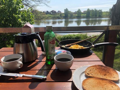 a picnic table with food and coffee and a view of a river at " Bernies Seeglück" in Penzlin