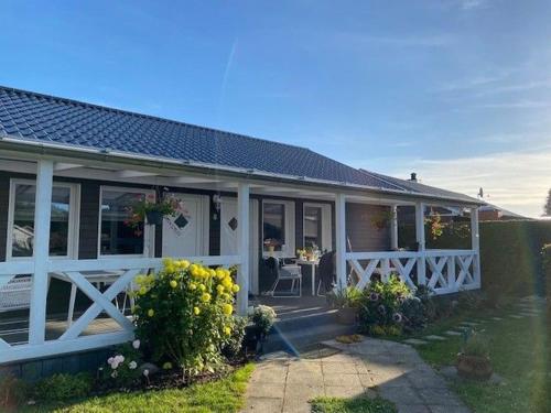 a house with a white fence and a porch at Bungalow "Sonnenschein" in Wustrow