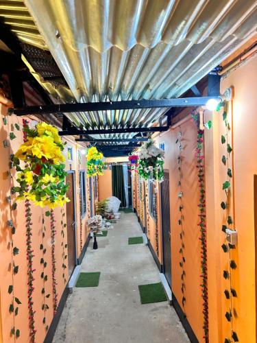 a hallway with flowers and plants on the walls at Sweet Home Lodge in Guwahati