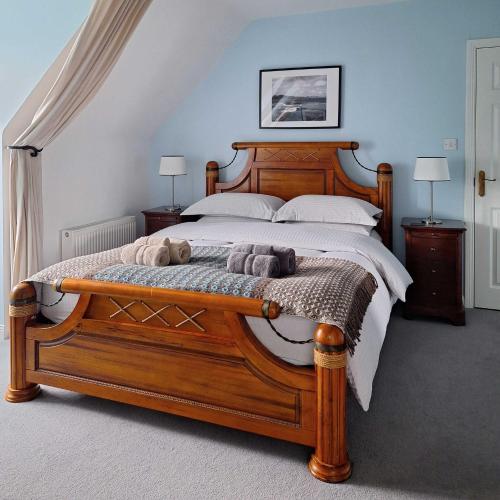 a bedroom with a large wooden bed with two pillows at Valhalla BnB in Kenmare