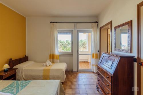 博薩的住宿－Malaspina Hotel & Resort，一间卧室设有两张床、一个梳妆台和窗户。