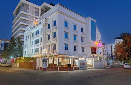 a white building in front of a building at Click White House Residency, Vadodara in Vadodara