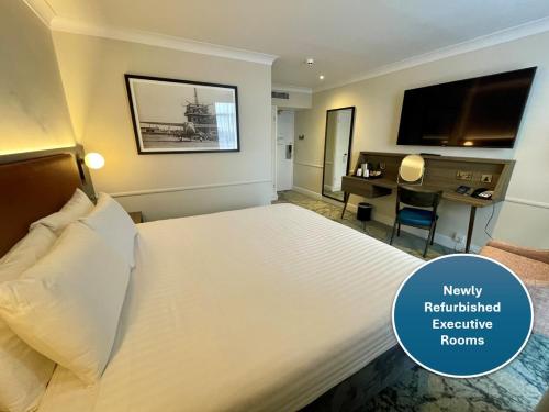 una camera d'albergo con un grande letto e una scrivania di London Croydon Aerodrome Hotel, BW Signature Collection a Croydon