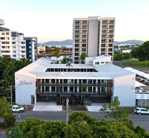 a large white building in front of some buildings at Belmoral Corporate Suites in Townsville