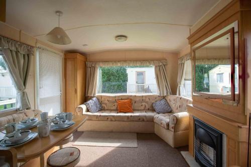 ein Wohnzimmer mit einem Sofa und einem Tisch in der Unterkunft Skegness Caravans in Skegness