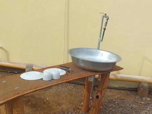 a mixing bowl on a wooden table with three white bowls at Camping Lamadrague in Opuwo