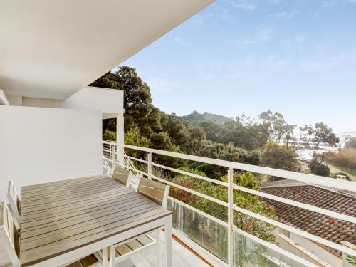 balcón con banco de madera y vistas en Modern studio with AC and large terrace on the beach in Cavalaire - Welkeys en Cavalaire-sur-Mer