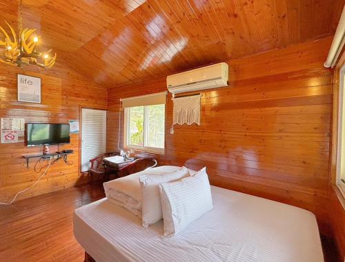 南庄乡南苑莊園 NanYuan Resort Manor的一间卧室设有木墙、一张床和电视。