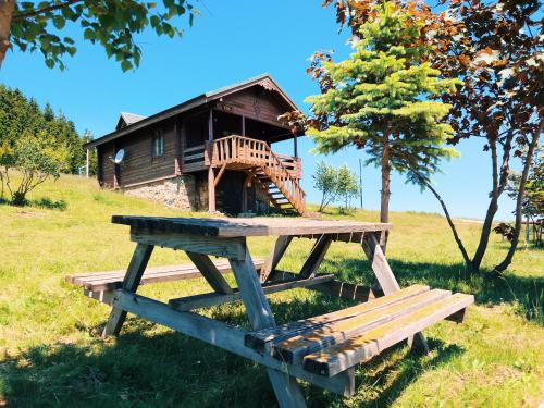 a wooden picnic table in front of a house at Birun Kumbet Dag Evi in Kumbet