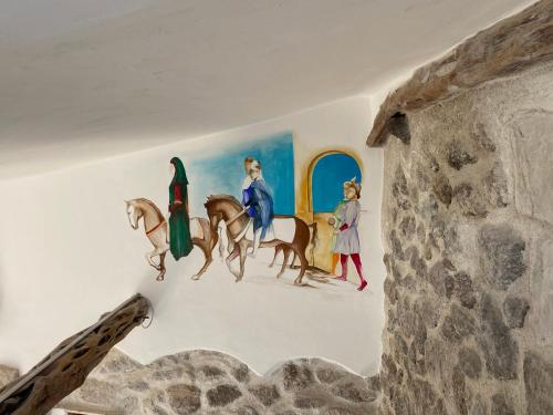 a painting of nuns on horses on a wall at B&B Domos Mi & Ro in Castelsardo