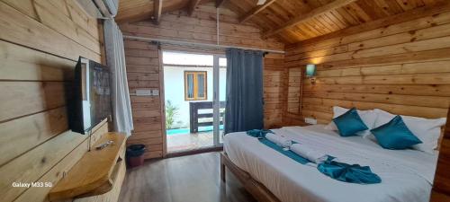 - une chambre avec un lit dans une cabane en bois dans l'établissement Sand Tent Beach House PALOLEM, à Canacona