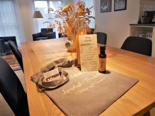 una bottiglia di vino seduta su un tavolo di legno di Inseldomizil Stolpe - Urlaub unter Reet auf Usedom a Stolpe auf Usedom