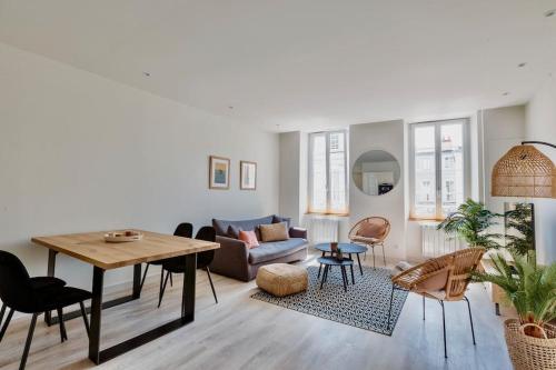 un salon avec une table et un canapé dans l'établissement Le Gambetta - La Rochelle centre 3 *, à La Rochelle