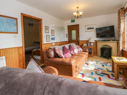 a living room with a couch and a fireplace at Alba Ben View in Spean Bridge