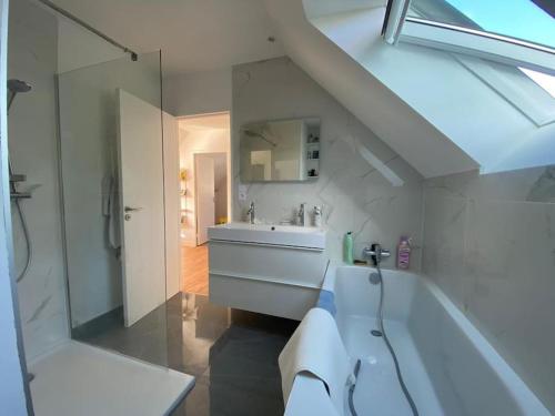 uma casa de banho com um lavatório, uma banheira e um chuveiro em Maison 3 chambres proche mer em Le Relecq-Kerhuon