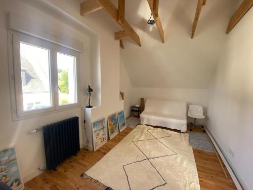 uma sala de estar com um sofá branco e uma janela em Maison 3 chambres proche mer em Le Relecq-Kerhuon