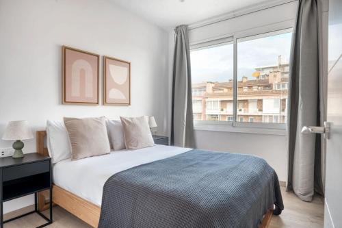 a bedroom with a bed and a large window at Blueground Pedralbes furnished BCN-92 in Barcelona