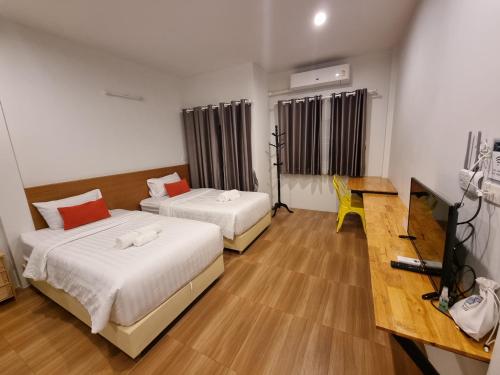 バンドゥにあるKandanai Placeのベッド2台とテーブルが備わるホテルルームです。
