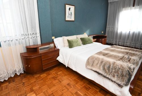 a bedroom with a large bed and a window at Casa Juncal sin cocina in Vilaboa