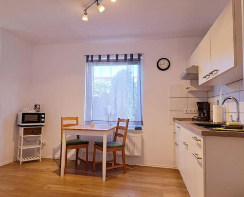 a kitchen with a table and chairs and a window at Schönes 1-Zimmer-Appartement, Büsum (4km) Nordsee in Oesterdeichstrich