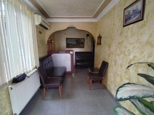ein Zimmer mit 2 Stühlen, einem Sofa und einem Fenster in der Unterkunft BK GOLD HOTEL in Batumi