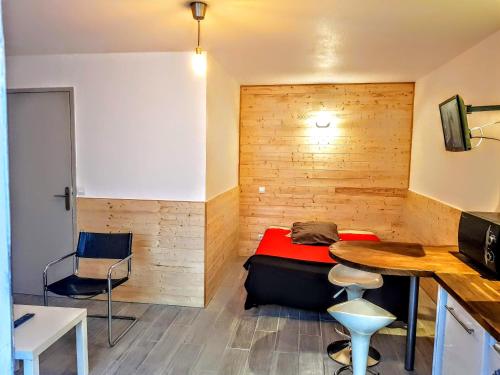 um pequeno quarto com uma cama e uma mesa em Studio Longchamp em Marselha