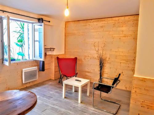 um quarto com duas cadeiras, uma mesa e uma janela em Studio Longchamp em Marselha